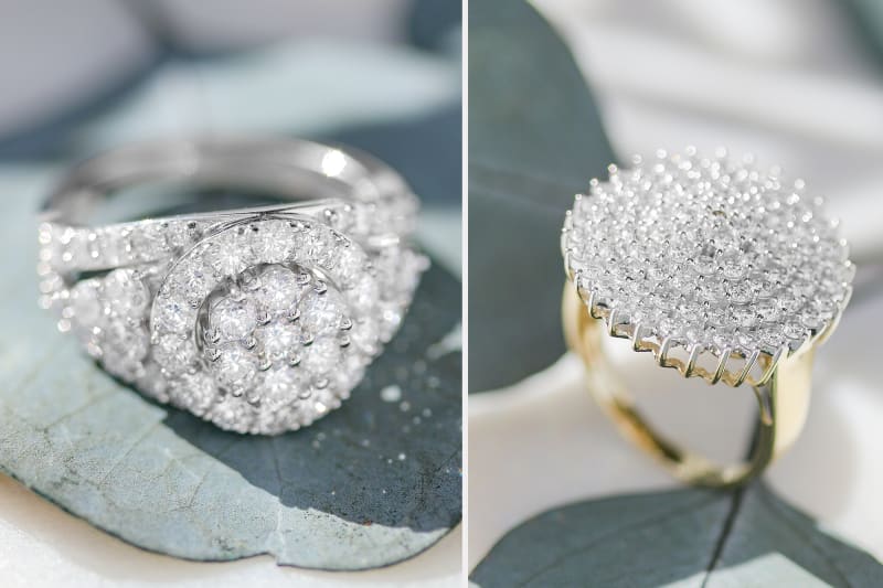 a silver diamond encrusted ring on the left and a gold on the right 