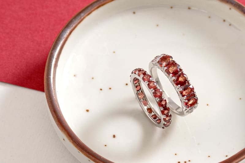 The image shows a silver garnet ring next to a labradorite ring. 