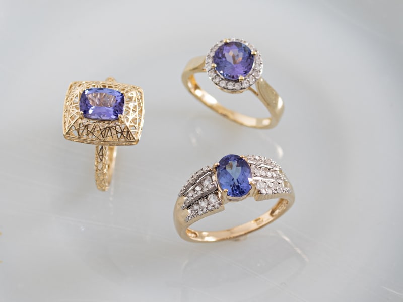 Photo of three blue tanzanite rings all set in gold. 