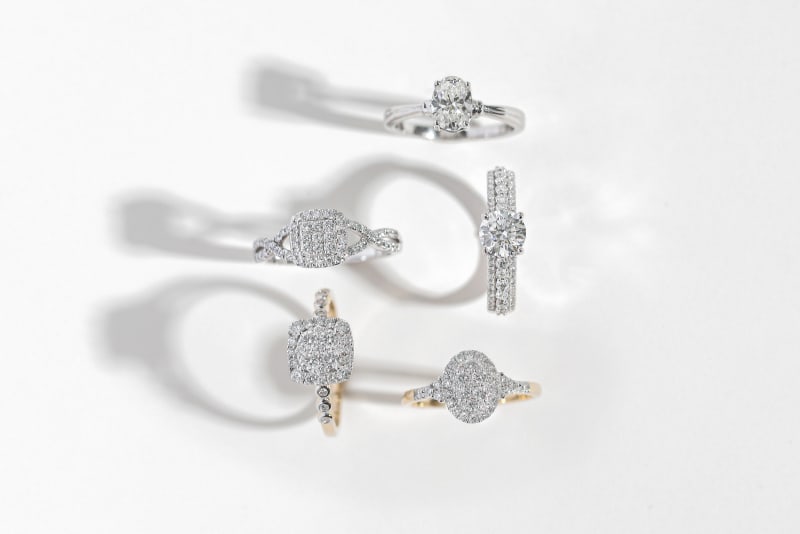 examples of five different styles of lab-grown diamond rings in yellow gold and silver settings 