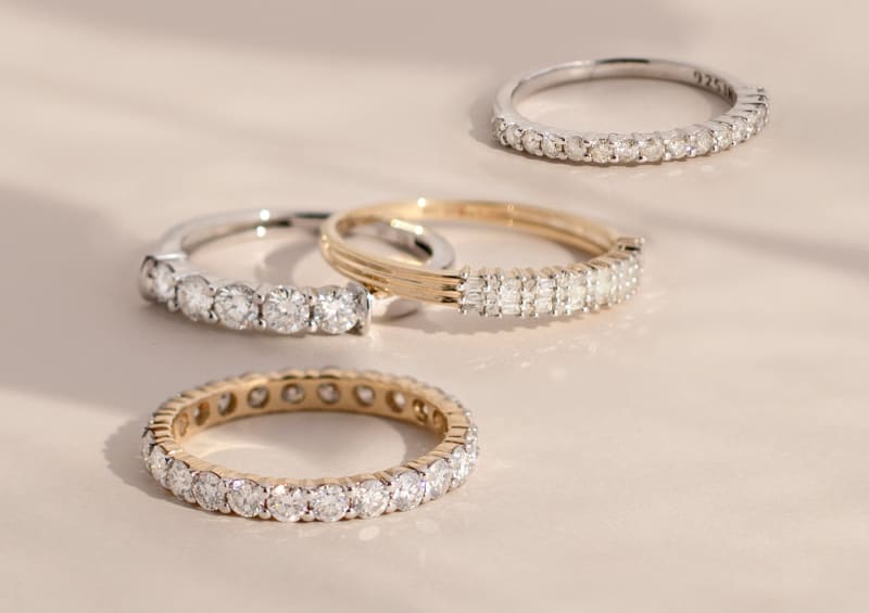 An assortment of silver and gold moissanite rings. 