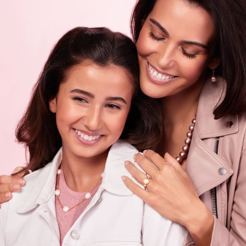 mother hugging daughter both wearing jewelry for mother's day