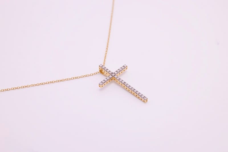 a gold and diamond studed cross pendant