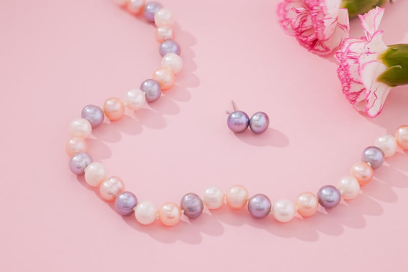 a white, pink and purple pearl strand necklace 
