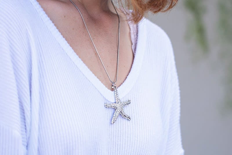 a silver and bedazzled starfish pendant necklace 
