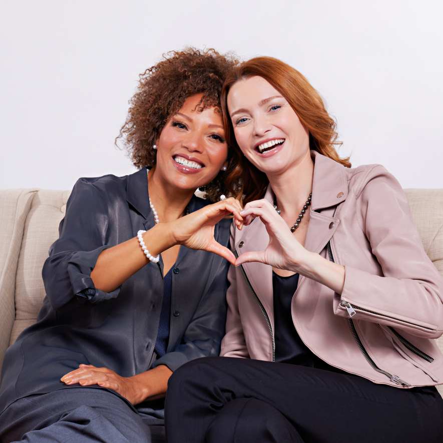 Two women making hearts with their hands 