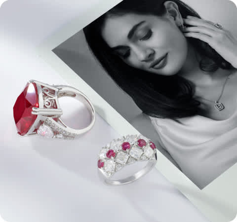 polaroid photo a woman wearing jewelry with red stone jewelry laying next to it