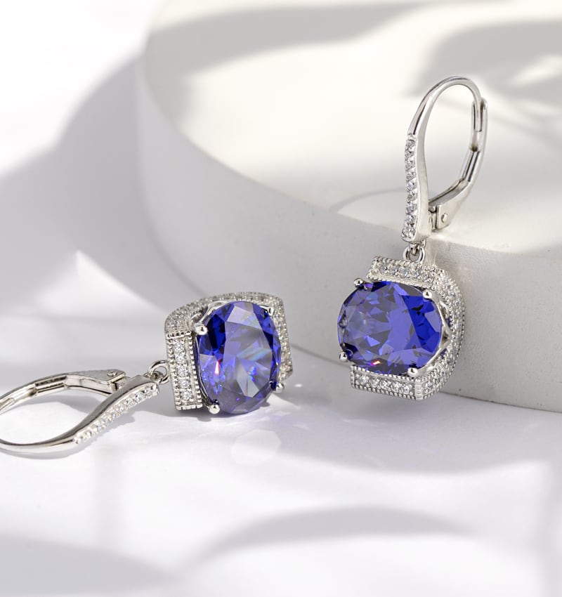 woman wearing Vanna K jewelry and blue stone drop earrings 