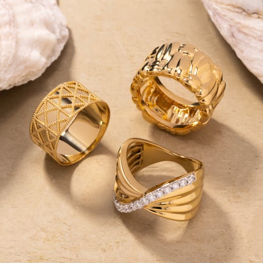 Multiple gold rings featured on sand 
