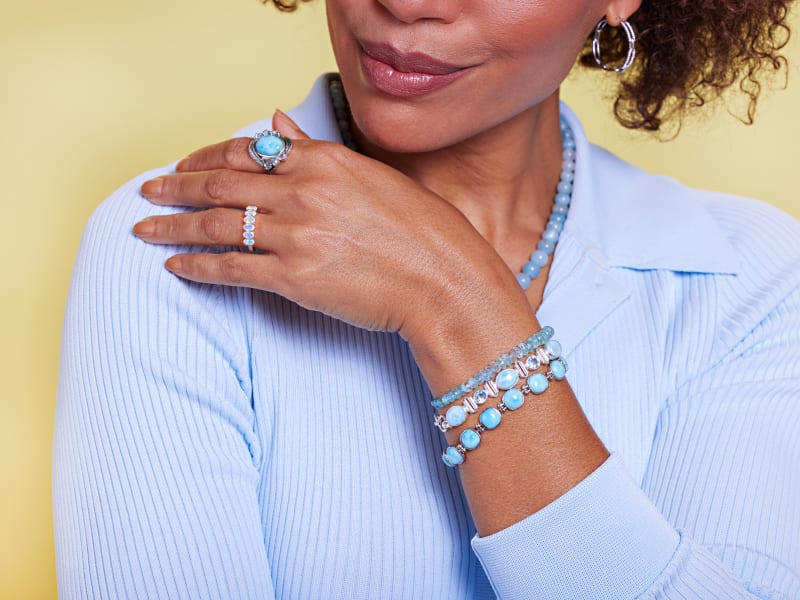 a model displays different blue gemstone and silver jewelry 