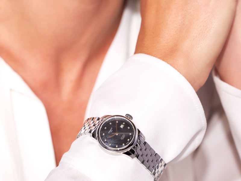 a model wears a silver metal link watch 