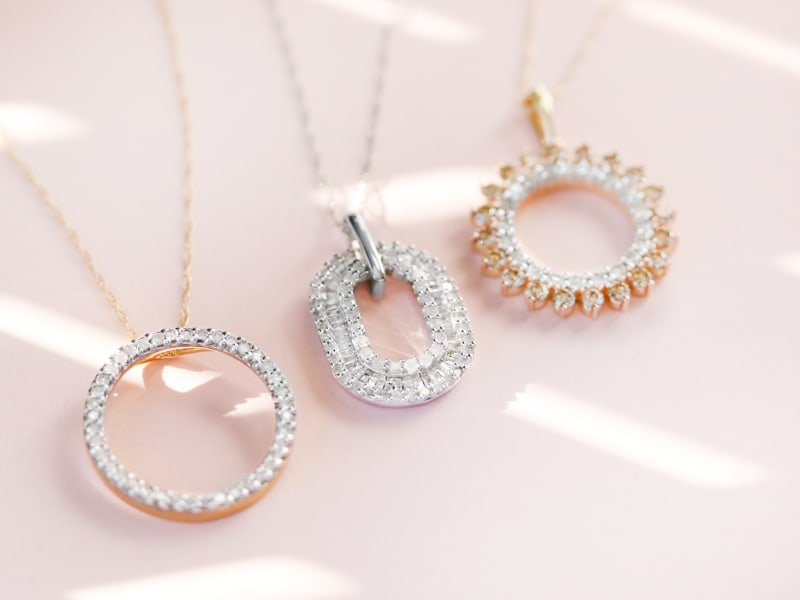 three detailed and multi-diamond gold and silver necklaces 