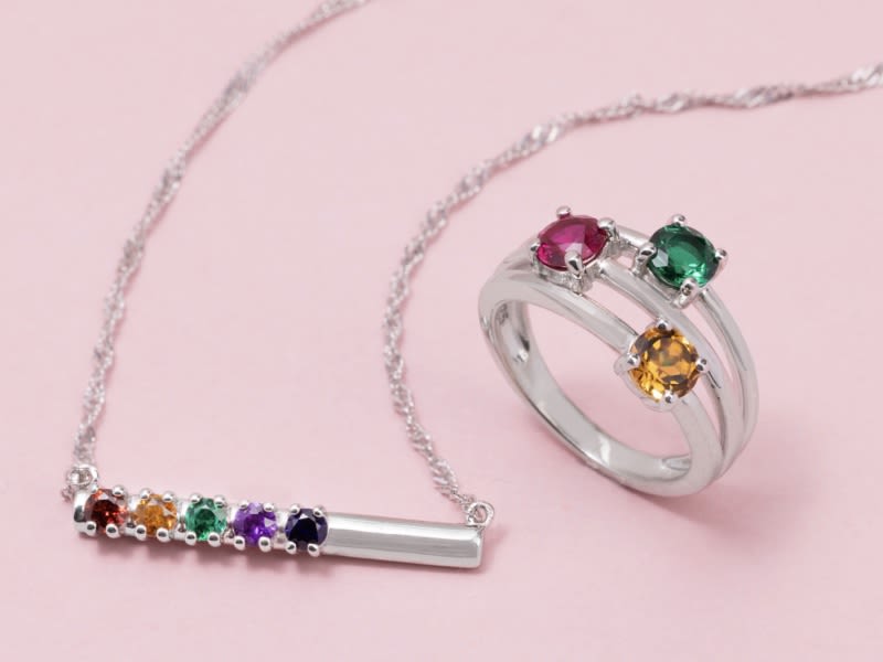 A silver chain and ring with multicolored gemstones. 