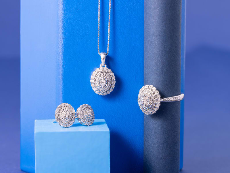 A set of diamond earrings with a matching necklace and ring. 