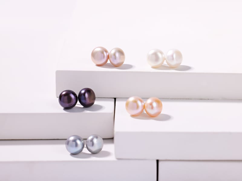 A set of five pairs of multicolored pearl stud earrings 