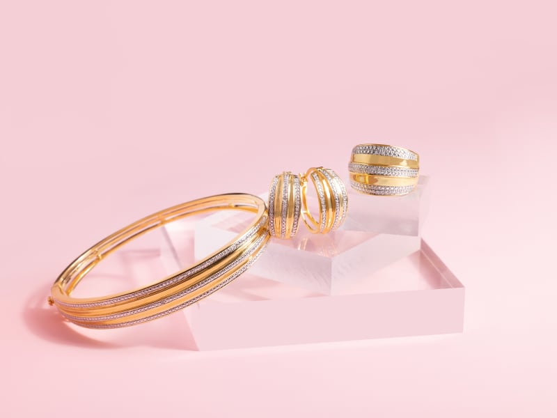 A diamond and gold-plated set of hoop earrings and a matching band ring and bangle bracelet. 