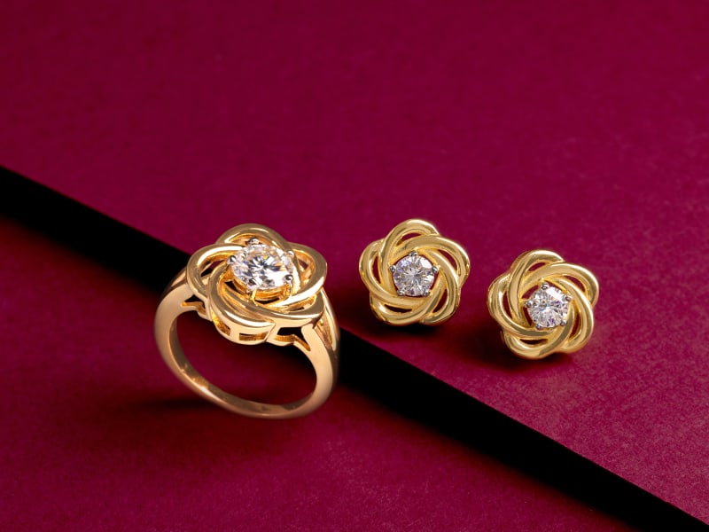 A a set of floral gold and moissanite earrings with a matching ring. 