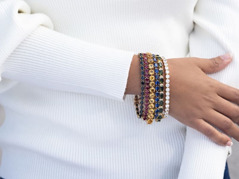 Six tennis bracelets side-by-side in different jewel tones 