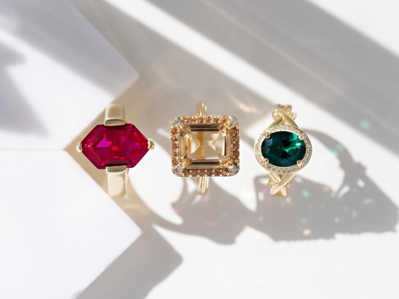 A trio of gold-plated birthstone rings with different shapes, cuts and colors 