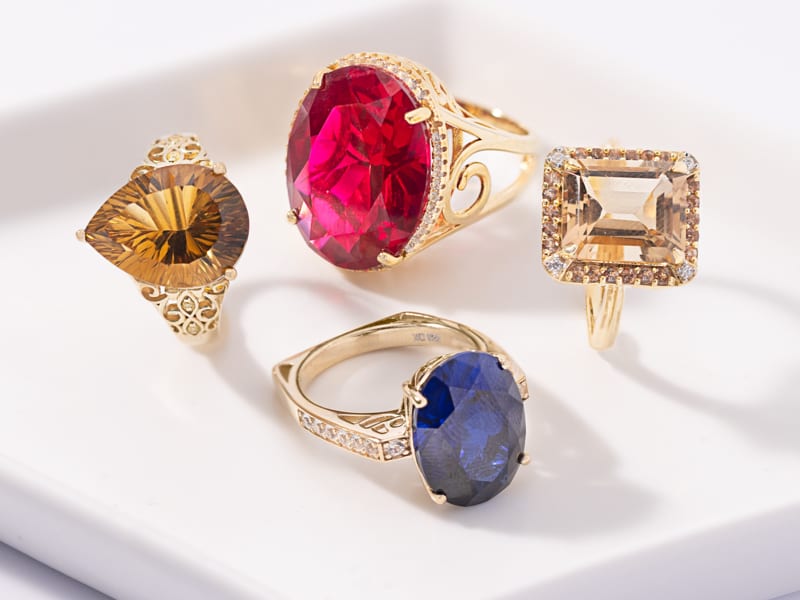 Four statement rings with different colored gemstones 