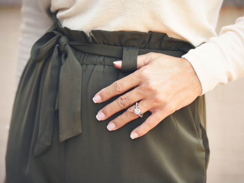 A woman in paper bag pants wearing a moissanite ring 
