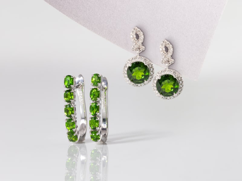 Two sets of silver and chrome diopside earrings, one hoop-style and one drop-style 