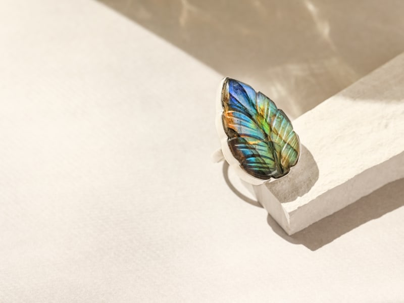 An iridescent feather-shaped ring 
