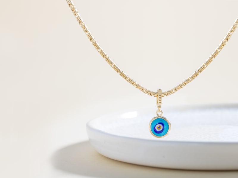 A gold and blue crystal evil eye pendant necklace 