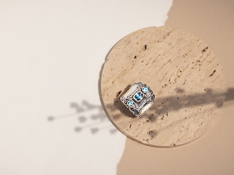 A thick silver ring with blue gemstones 