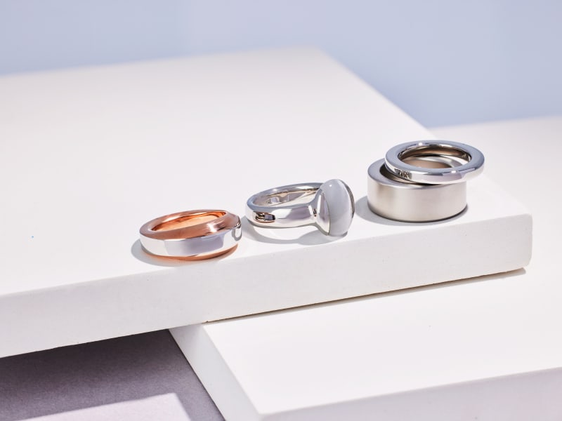 A variety of simple silver band rings sitting in a row 