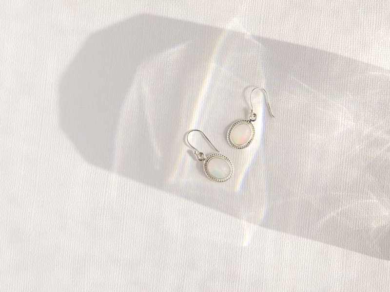 A pair of white opal and silver dangle earrings 
