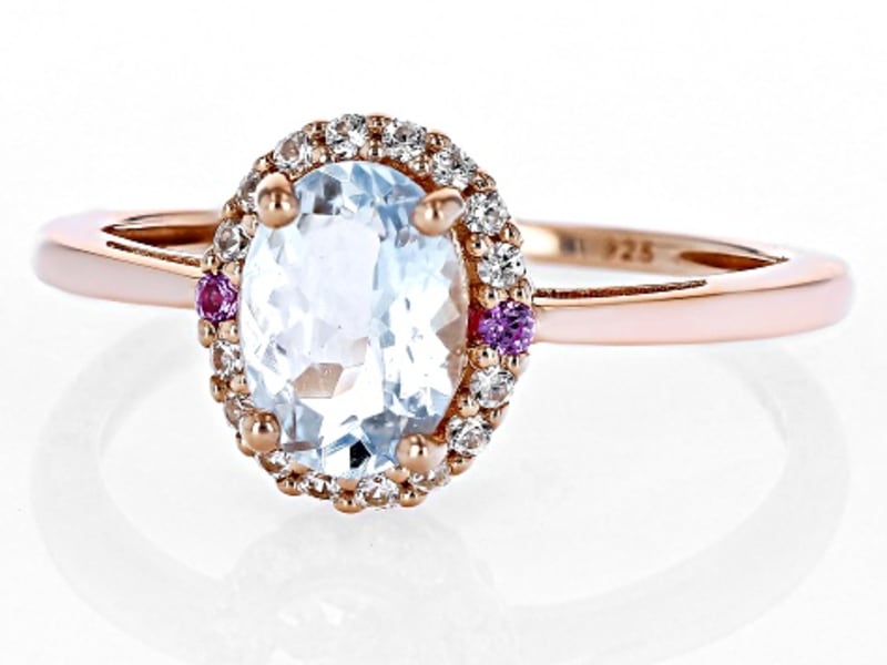 An aquamarine ring with a rose gold band and a multicolored gem halo 