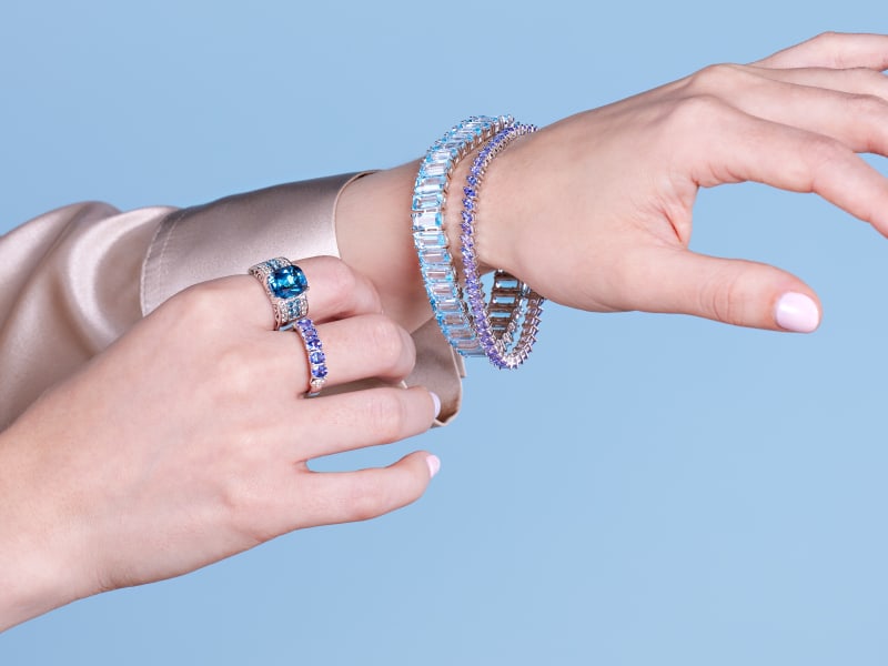 A woman wearing blue gemstone bracelets and rings 