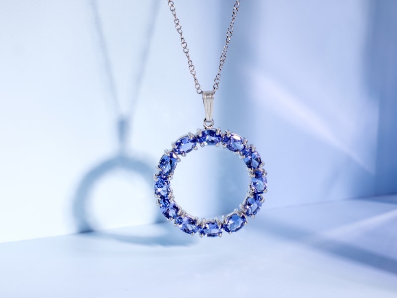 A silver circular tanzanite pendant necklace 