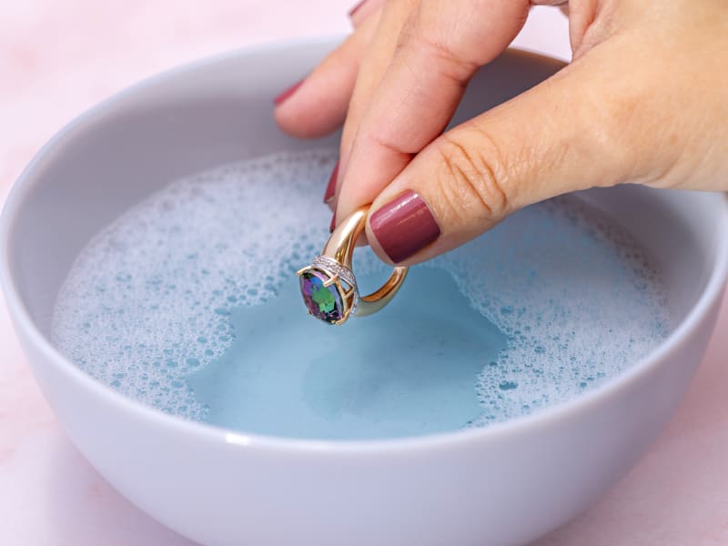 Soaking plated jewelry in warm soapy water 