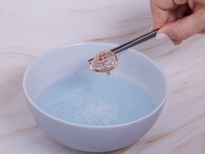 Putting copper jewelry in warm soapy water  