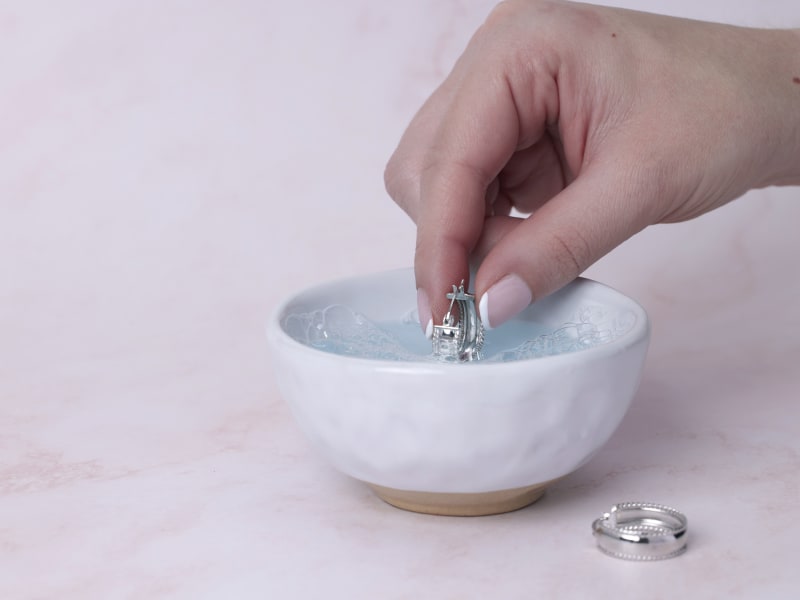 Soaking silver jewelry in warm, soapy water 